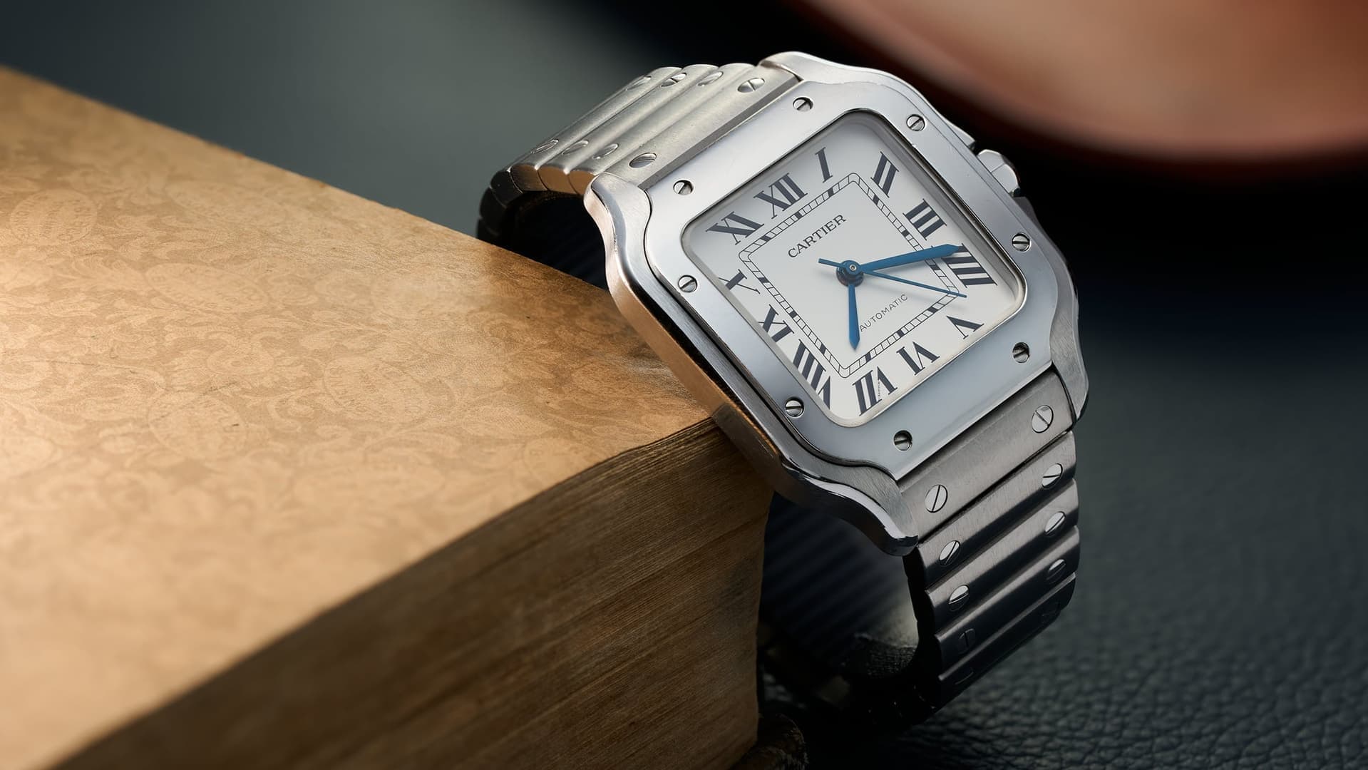 A Cartier Santos resting on a wooden block